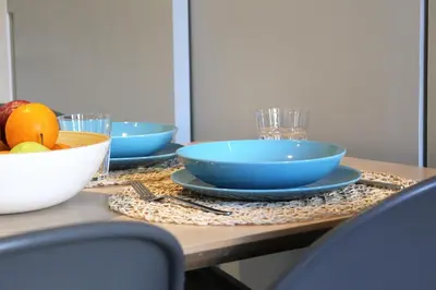 a table with two blue bowls and a bowl of fruit at Piso nuevo al lado de la Sagrada Familia. in Barcelona