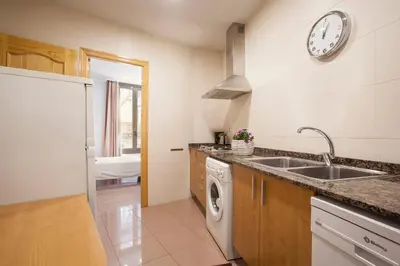 a kitchen with a sink and a clock on the wall at BCNGOTIC 11 in Barcelona