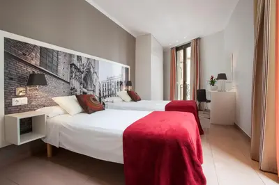 a hotel room with two beds and a brick wall at BCNGOTIC 31 in Barcelona