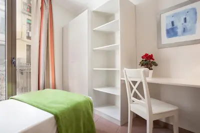 a bedroom with a bed and a chair and shelves at BCNGOTIC 31 in Barcelona