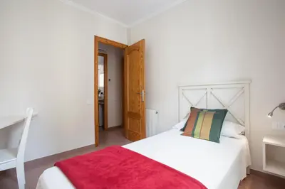 a bedroom with a white bed with a red blanket on it at BCNGOTIC 41 in Barcelona