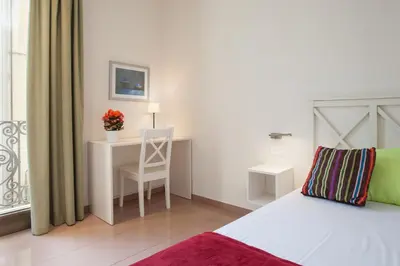a bedroom with a bed and a desk with a chair at BCNGOTIC 41 in Barcelona