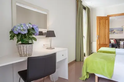 a bedroom with a bed and a desk with a vase of flowers at BCNGOTIC 41 in Barcelona