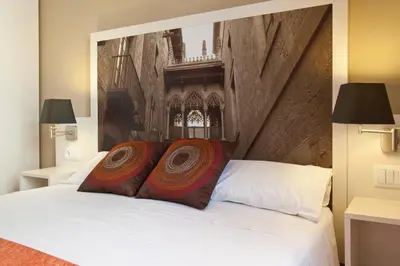 a bedroom with a white bed with two red pillows at BCNGOTIC 33 in Barcelona