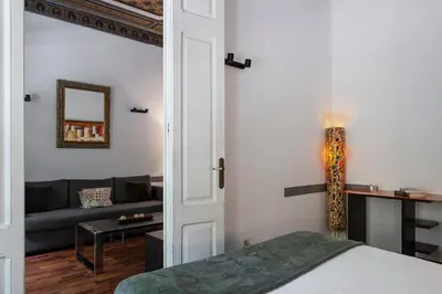a bedroom with a bed and a living room with a couch at AB Casanova Apartment in Barcelona
