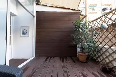 a wooden deck with a door and a plant at AB Rossello Center Terrace in Barcelona