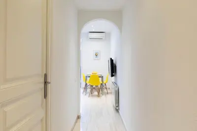 a hallway with a table and yellow chairs at AB Rossello Center Terrace in Barcelona