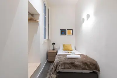 a small bedroom with a bed and a window at AB Centric Universitat in Barcelona