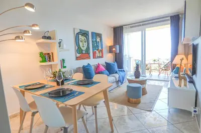 a dining room and living room with a table and chairs at Palma Fiesta Apartment by Hello Homes Sitges in Sant Pere de Ribes