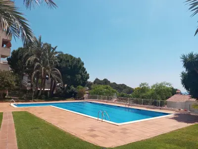 a swimming pool in the middle of a yard at Palma Fiesta Apartment by Hello Homes Sitges in Sant Pere de Ribes
