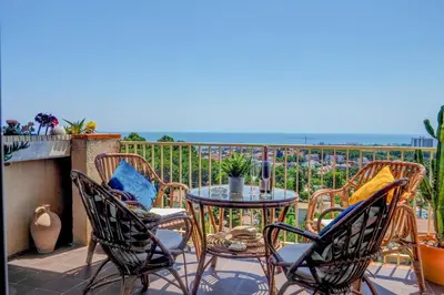 a patio with a table and chairs on a balcony at Palma Fiesta Apartment by Hello Homes Sitges in Sant Pere de Ribes
