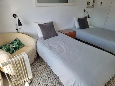 two beds and a couch in a room at Apart 2 habit vistas playa y montaña lift parking in Calella