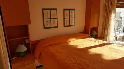a bedroom with an orange bed and a window at Apart 2 habit vistas playa y montaña lift parking in Calella