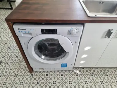 a washing machine in a kitchen under a counter at Apart 2 habit vistas playa y montaña lift parking in Calella