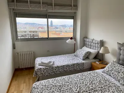 a bedroom with two beds and a window with a view at Sea views & city skyline in Barcelona