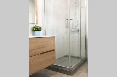 a bathroom with a glass shower with a wooden vanity at Sunny apartment Gracia - Joanic Renovated in Barcelona