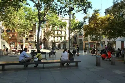 a group of people sitting on a park bench at Sunny apartment Gracia - Joanic Renovated in Barcelona