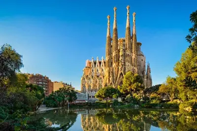a large cathedral with a reflection in the water at Sunny apartment Gracia - Joanic Renovated in Barcelona