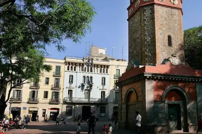 a building with a tower with a clock on it at Sunny apartment Gracia - Joanic Renovated in Barcelona
