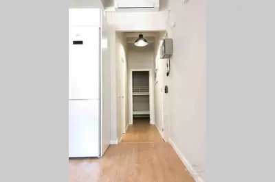 a hallway with white walls and a hard wood floor at 2 BEDROOM APARTMENT SANTS in Barcelona