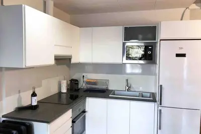 a white kitchen with a sink and a refrigerator at 2 BEDROOM APARTMENT SANTS in Barcelona