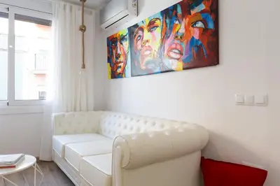 a living room with a white couch and a painting at Besos Beach Gem II By MyRentalHost in Sant Adria de Besos