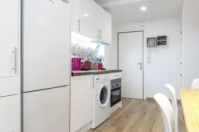 a kitchen with white cabinets and a washer and dryer at Besos Beach Gem II By MyRentalHost in Sant Adria de Besos