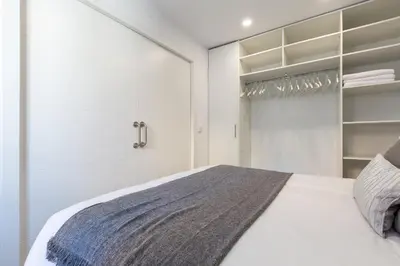 a white bedroom with a bed and a closet at Besos Beach Gem II By MyRentalHost in Sant Adria de Besos