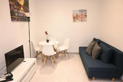 a living room with a blue couch and a table at Homenfun Barcelona Les Corts in Barcelona