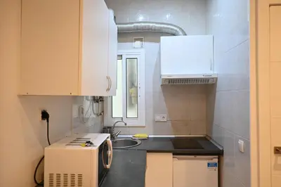 a small kitchen with a sink and a microwave at Homenfun Barcelona Les Corts in Barcelona