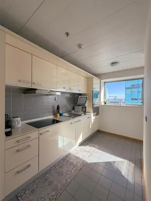 a kitchen with white cabinets and a sink and a window at Sotell Apartment Gran Via Europa BCN in Las Corts