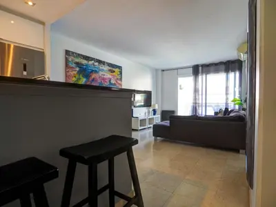 a living room with a couch and a table at Mediterraneo Seaview Apartment by Hello Homes Sitges in Sitges