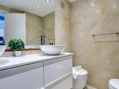 a bathroom with a white sink and a toilet at Mediterraneo Seaview Apartment by Hello Homes Sitges in Sitges