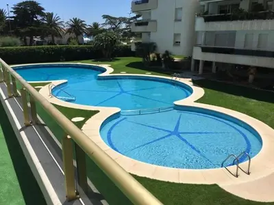 a large swimming pool next to a building at Mediterraneo Seaview Apartment by Hello Homes Sitges in Sitges