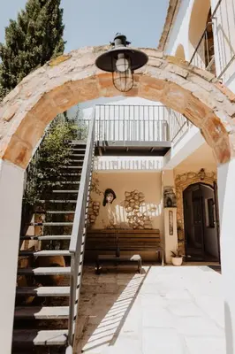 an archway leads up to the stairs of a house at Cal Pau Cruset in Torrellas de Foix
