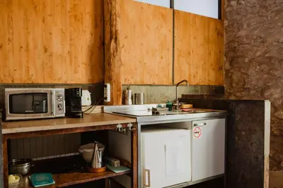 a small kitchen with a microwave and a sink at Cal Pau Cruset in Torrellas de Foix