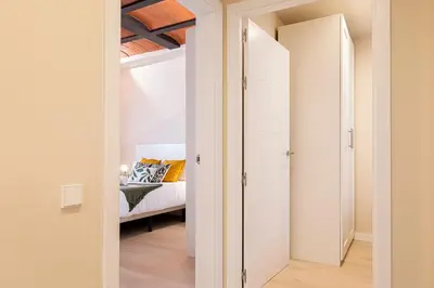 a bedroom with white walls and a bed in a room at Barcelona Touch Apartments - Campalans in Hospitalet de Llobregat