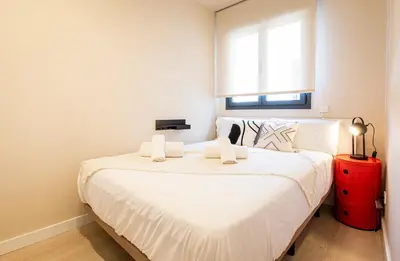 a bedroom with a large white bed and a window at Barcelona Touch Apartments - Campalans in Hospitalet de Llobregat
