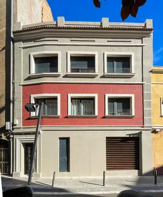 a red and white building on a city street at Barcelona Touch Apartments - Campalans in Hospitalet de Llobregat