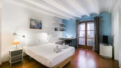 a bedroom with a white bed and a blue wall at Bed&BCN Gracia III in Barcelona