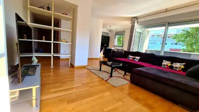 a living room with a black couch and a television at Forum-CCIB-Relax Flats in Sant Adria de Besos