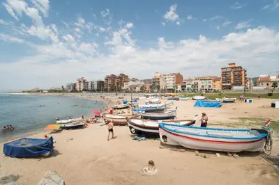 people on a beach with boats on the sand at Vilamarlux V in Vilassar de Mar