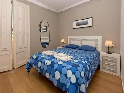 a bedroom with a blue and white bed and a mirror at Apartment Sagrada Familia Grassot - Industria by Interhome in Barcelona