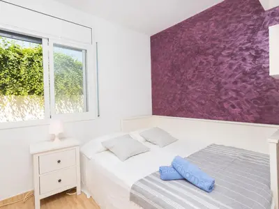 a bedroom with a bed and a purple wall at Holiday Home Nova by Interhome in Segur de Calafell