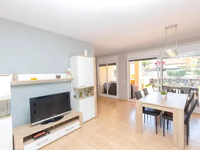 a living room with a dining room table and a tv at Holiday Home Nova by Interhome in Segur de Calafell