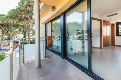 a balcony with glass doors on a building at Aparthotel Las Palmeras Castelldefels in Castelldefels