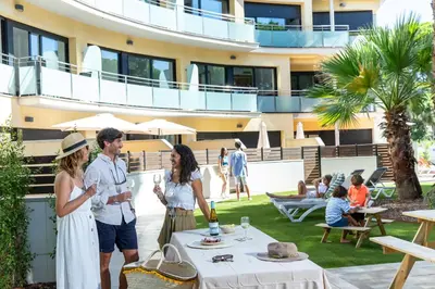 a group of people standing in front of a building at Aparthotel Las Palmeras Castelldefels in Castelldefels