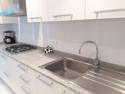 a kitchen with a sink and a stove at Suitur apartamento primera linea mar vistas playa in Canet de Mar