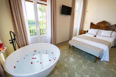 a bathroom with a tub and a bed and a tub at Bolet Casa Modernista in Castellví de la Marca