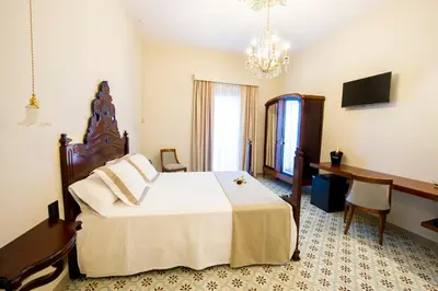 a bedroom with a large bed and a chandelier at Bolet Casa Modernista in Castellví de la Marca